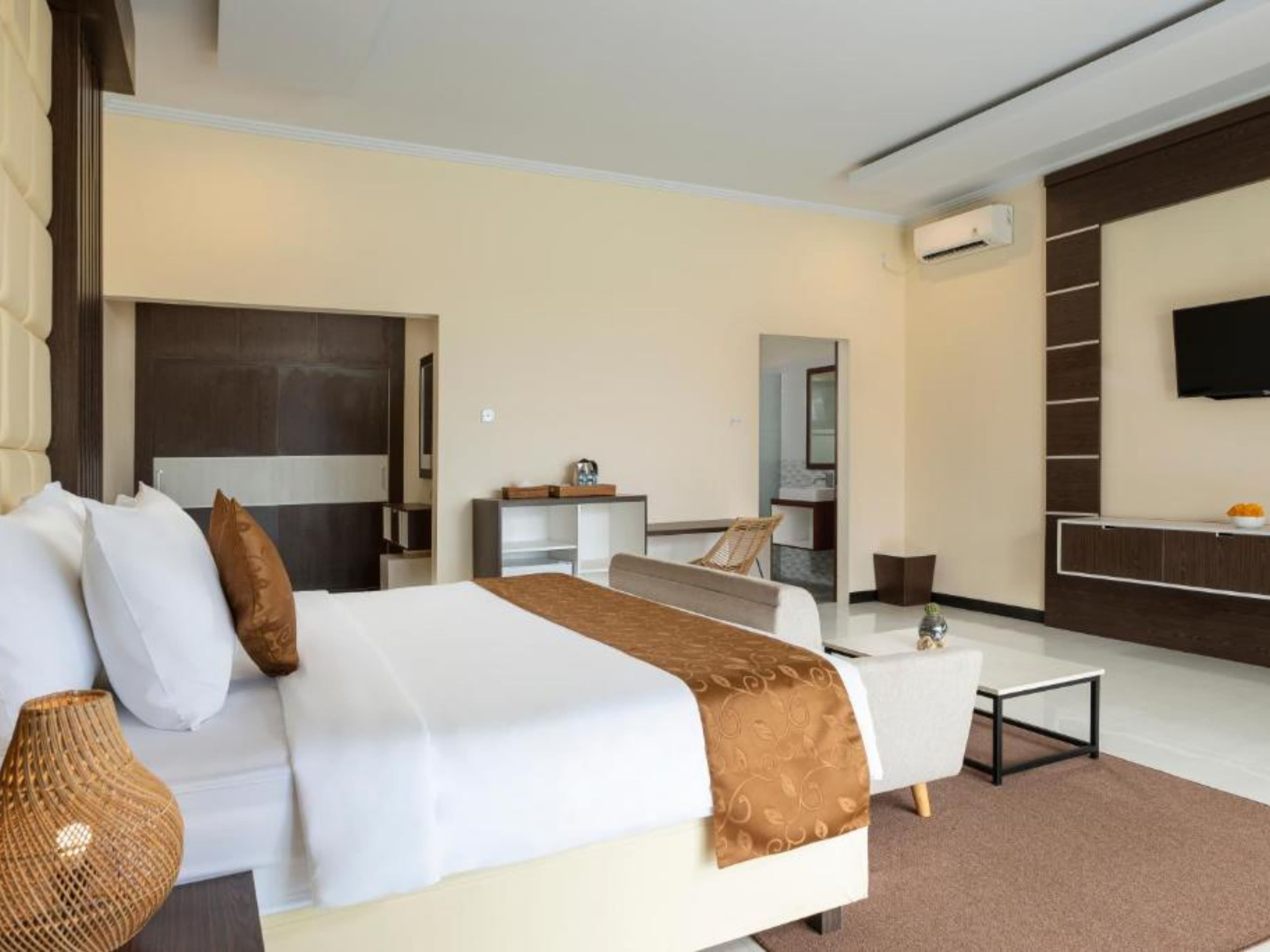 Deluxe Double Room — bedroom with TV and seating